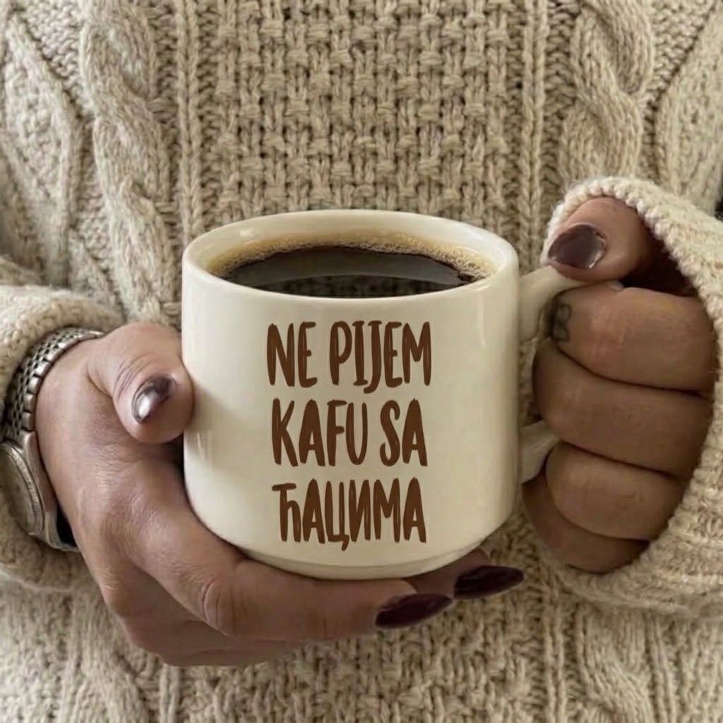 Krem šoljica puna kafe u rukama, ćirilični natpis Ne pijem kafu sa ćacima